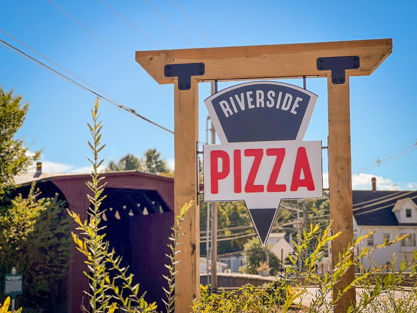 Riverside Pizza highway sign with the Contoocook covered bridge in the background